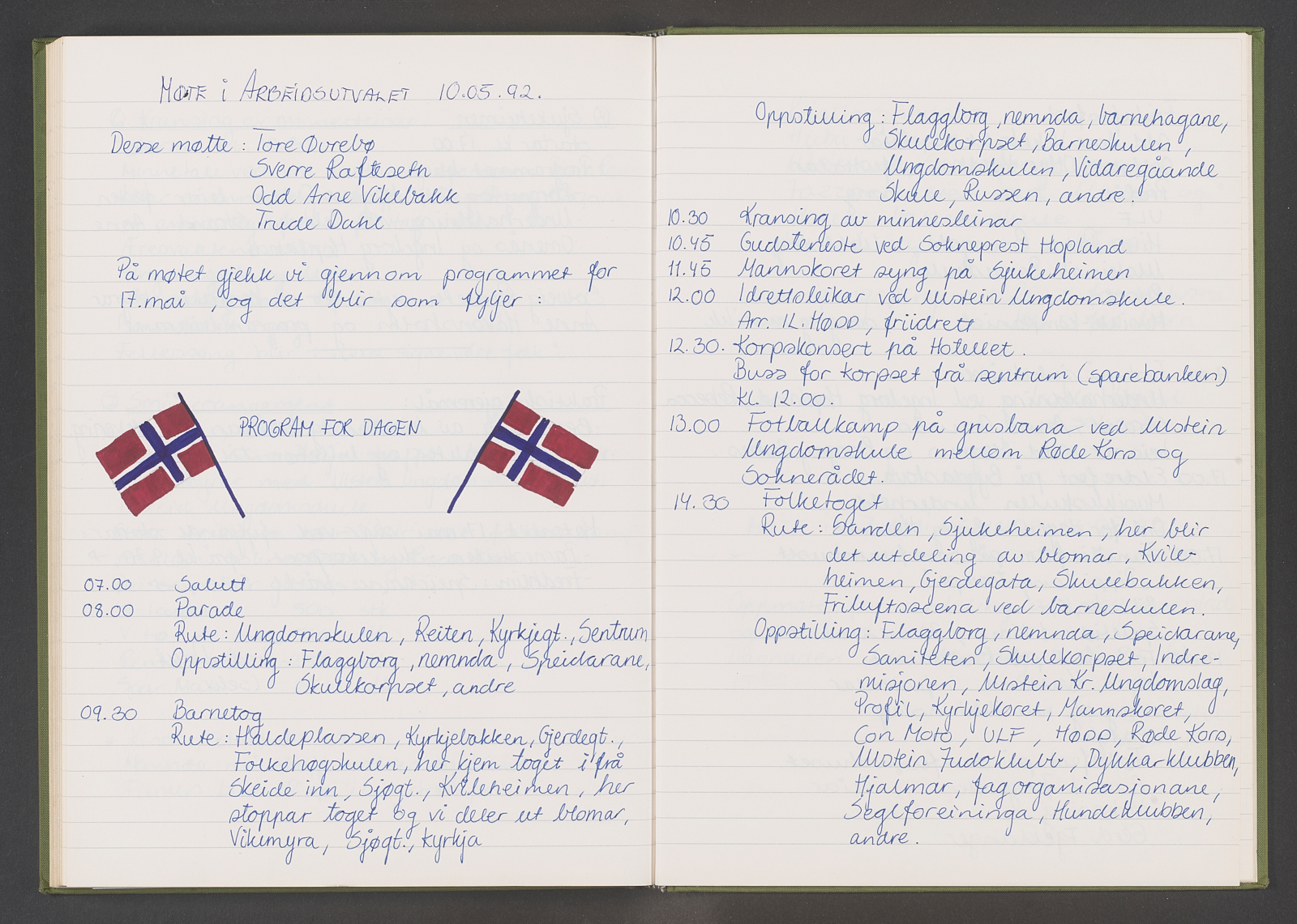Handskriven møteprotokoll med blått blekk. Det er teikna to norske flagg på eine sida.