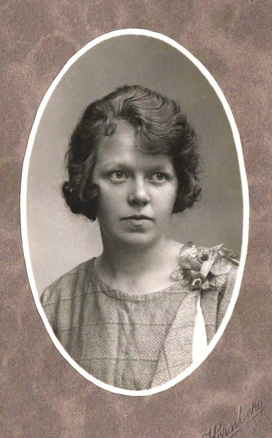 Portrettbilde av ei ung kvinne, i svart/kvitt. Bildet er gamalt og har passepartout med oval utskjering mot bildet.