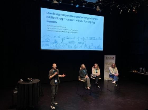 Paneldebatt med tre kvinner og ein mannleg konferansier som pratar