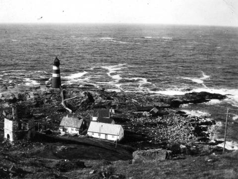 Eit tydeleg gamalt bilde tatt ovanfrå ned mot eit nes. Nedst på neset står ei fyrlykt. Havet er ruskete bak. Heilt fremst i bildet er den gamle sekskanta fyrlykta. Mellom fyrlyktene er fyrvaktarbustaden og andre hus rundt.